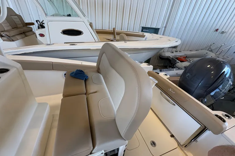 Slide: The Image of 2024 Scout 215 XSF boat interior with seating and outboard motor in showroom. - 8