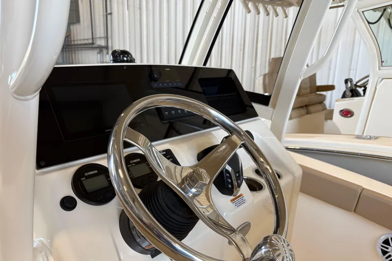 Slide: The Image of 2024 Scout 215 XSF boat dashboard with steering wheel and Yamaha controls. - 9