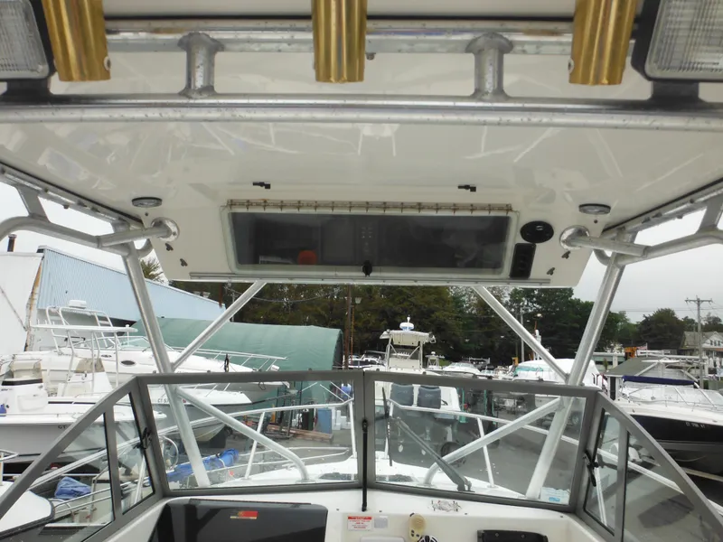 Slide: The Image of 1997 Robalo 2140 Walkaround boat cockpit view with hardtop and rod holders. - 13