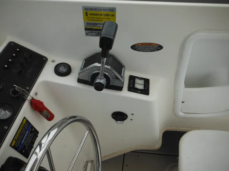 Slide: The Image of 1997 Robalo 2140 Walkaround boat helm with steering wheel and throttle controls. - 21
