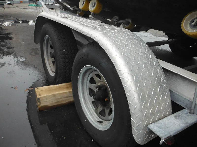 Slide: The Image of Trailer wheels of a 1997 Robalo 2140 Walkaround boat on a wet surface. - 42