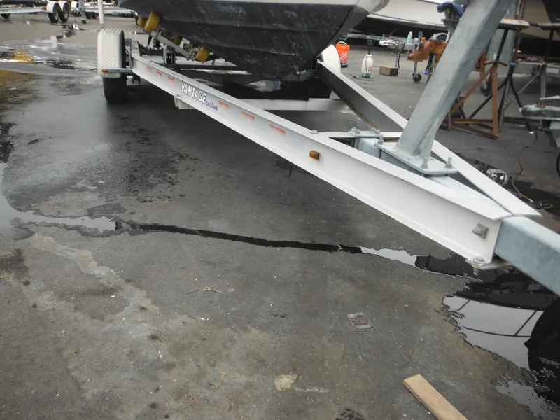 Slide: The Image of 1997 Robalo 2140 Walkaround boat on trailer in a marina. - 45