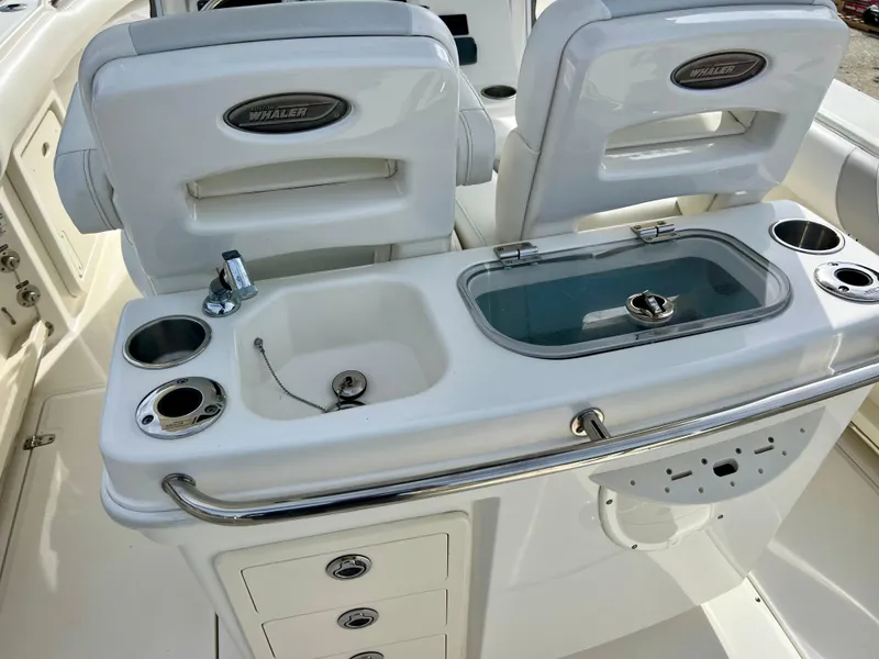 Slide: The Image of 2015 Boston Whaler 250 Outrage boat interior with sink and storage compartments. - 24