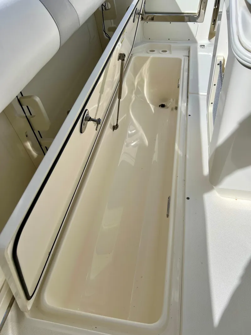 Slide: The Image of 2015 Boston Whaler 250 Outrage boat storage compartment with open lid. - 44