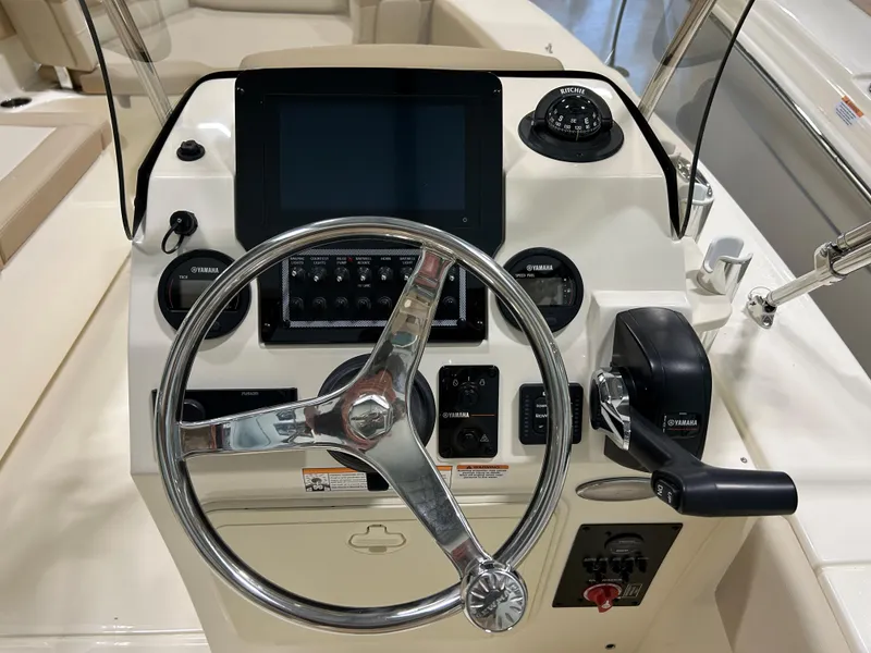 Slide: The Image of 2024 Scout 195 Dorado boat dashboard with steering wheel and control panel. - 5