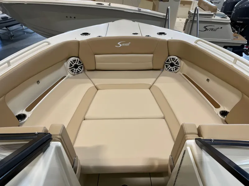 Slide: The Image of 2024 Scout 255 Dorado boat interior with beige seating and built-in speakers. - 6