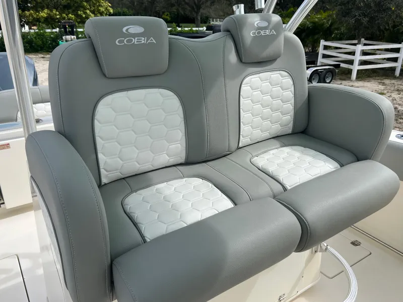 Slide: The Image of 2014 Cobia 296 Center Console boat, dual cushioned seats, gray and white upholstery. - 17