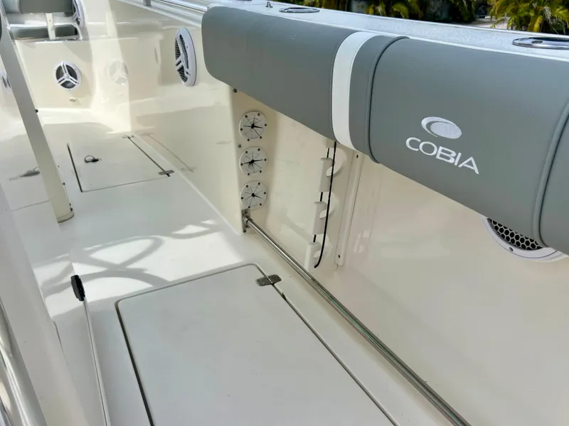 Slide: The Image of 2014 Cobia 296 Center Console boat interior with cushioned seating and storage compartments. - 23