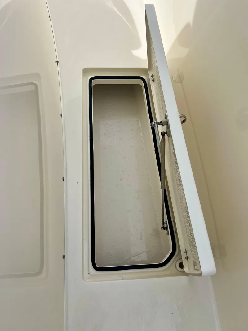 Slide: The Image of Open storage compartment on a 2014 Cobia 296 Center Console boat. - 36