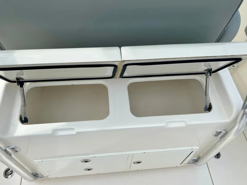 Slide: The Image of 2014 Cobia 296 Center Console storage compartments with open lids. - 37
