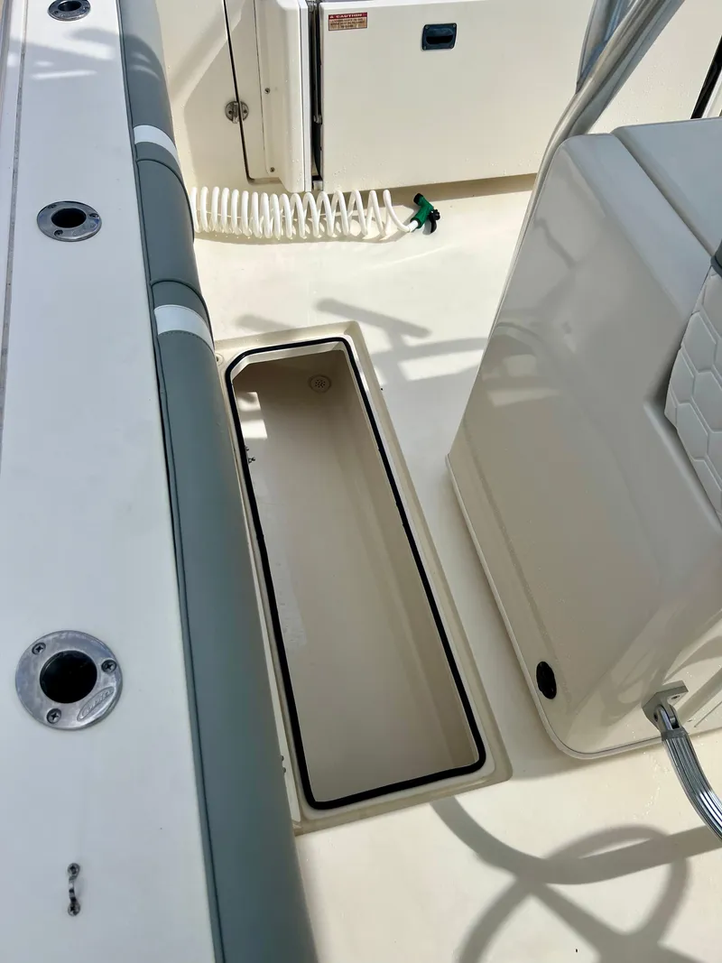Slide: The Image of 2014 Cobia 296 Center Console boat deck with open storage compartment. - 41