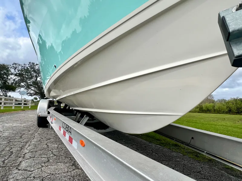Slide: The Image of 2014 Cobia 296 Center Console boat on a trailer, close-up of hull. - 7