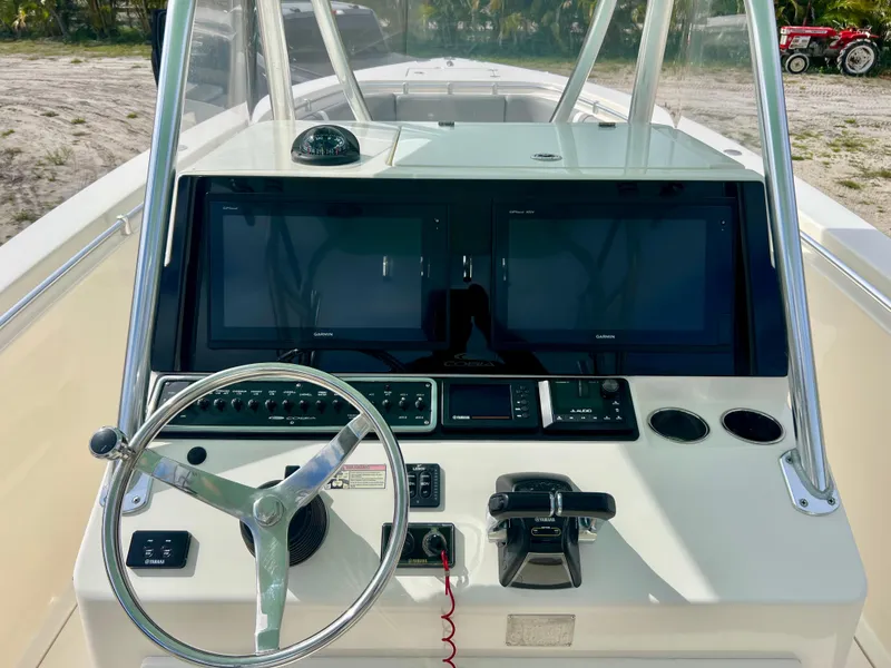 Slide: The Image of 2014 Cobia 296 Center Console boat dashboard with dual screens and steering wheel. - 8