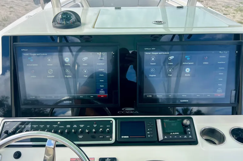 Slide: The Image of 2014 Cobia 296 Center Console dashboard with dual Garmin displays and navigation controls. - 9