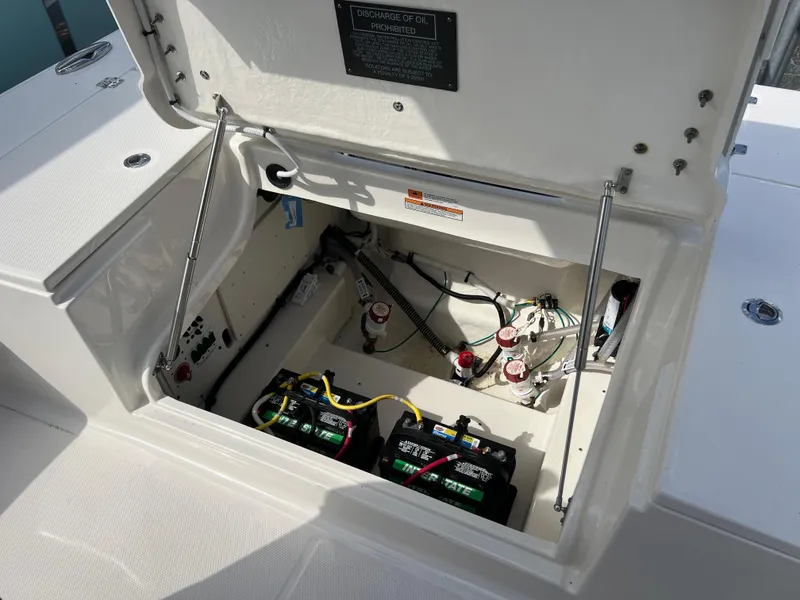 Slide: The Image of 2024 Robalo 246 Cayman boat battery compartment with dual batteries and wiring. - 15