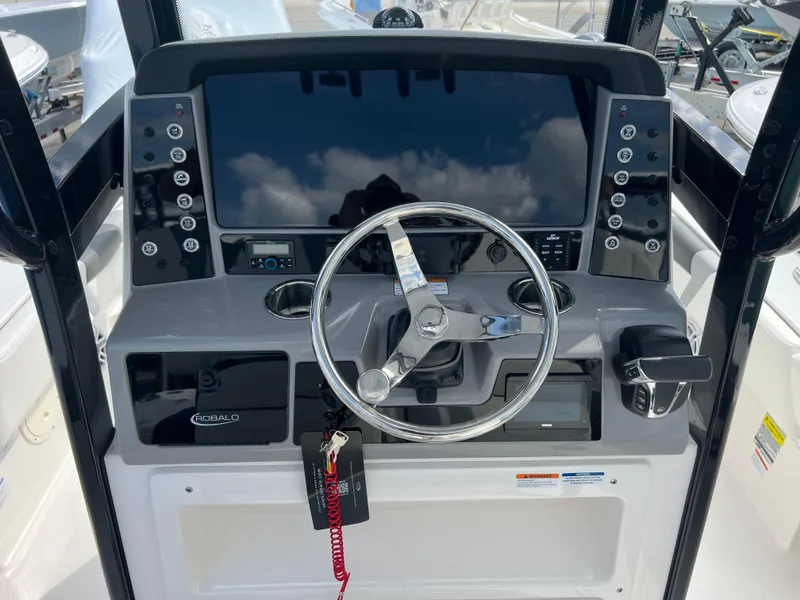 Slide: The Image of 2024 Robalo 246 Cayman boat dashboard with steering wheel and control panel. - 8