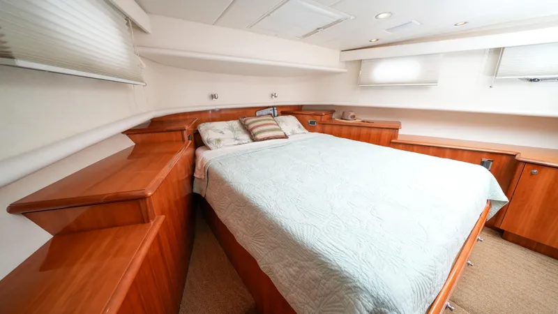Slide: The Image of Luxurious bedroom interior of 2002 Queenship 70 Baretta yacht with wooden cabinetry. - 13