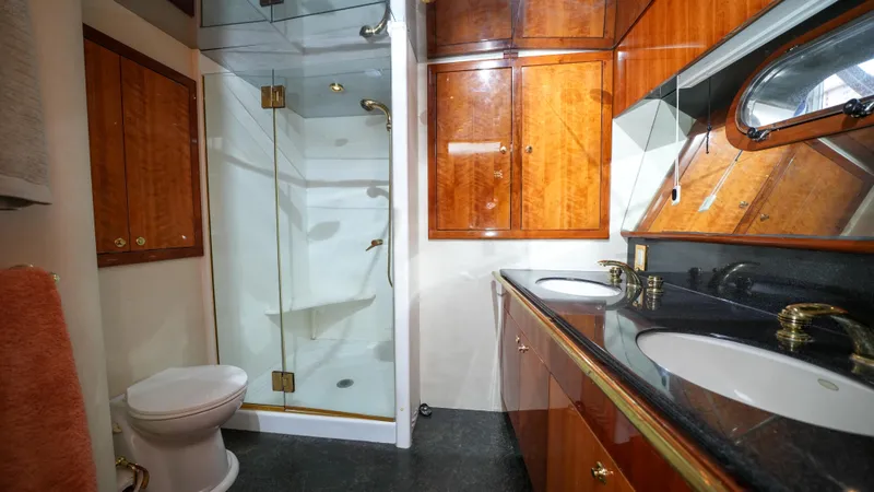 Slide: The Image of Luxurious bathroom in a 2002 Queenship 70 Baretta yacht with glass shower and wooden cabinets. - 15