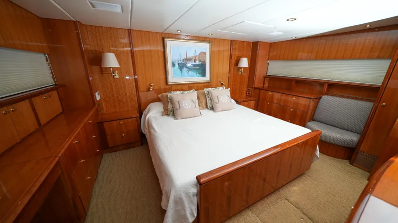 Slide: The Image of Luxurious master bedroom on a 2002 Queenship 70 Baretta yacht with wood paneling. - 17