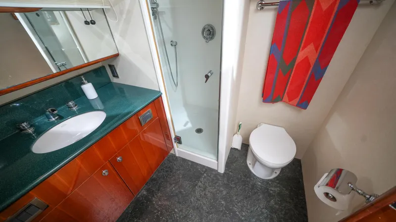 Slide: The Image of Luxurious bathroom in a 2002 Queenship 70 Baretta yacht with shower, sink, and toilet. - 18