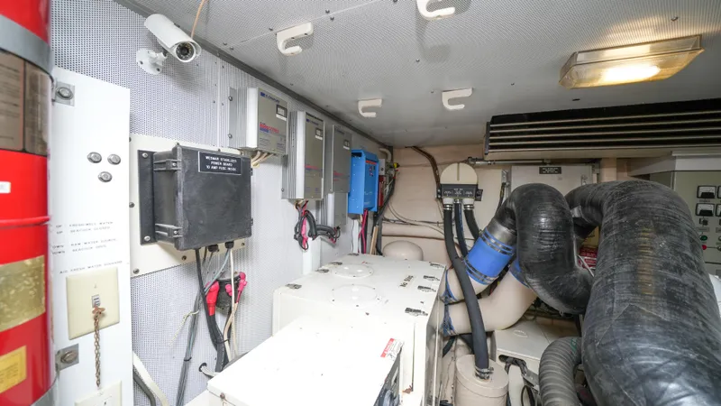 Slide: The Image of Engine room of a 2002 Queenship 70 Baretta yacht with various mechanical components. - 32