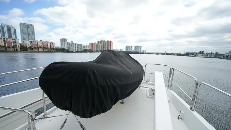Slide: The Image of Covered equipment on the deck of a 2002 Queenship 70 Baretta yacht, with cityscape in the background. - 36