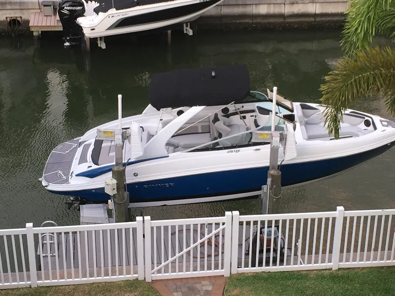 Slide: The Image of 2018 Rinker QX 26 boat docked on a lift in a canal. - 1