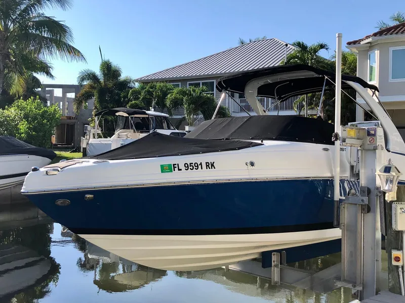 Slide: The Image of 2018 Rinker QX 26 boat docked in a sunny marina. - 11