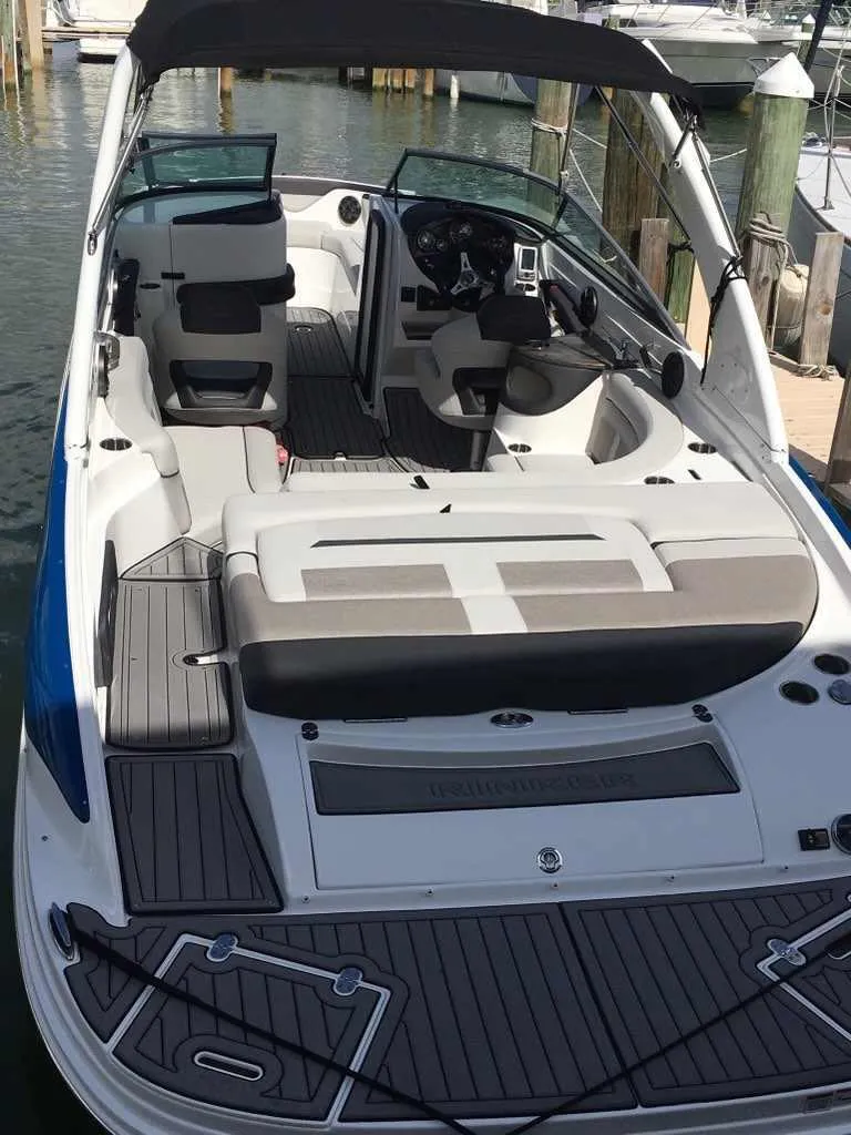 Slide: The Image of 2018 Rinker QX 26 boat docked, featuring spacious seating and modern design. - 14