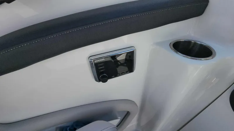 Slide: The Image of 2018 Rinker QX 26 boat interior with control panel and cup holder. - 16