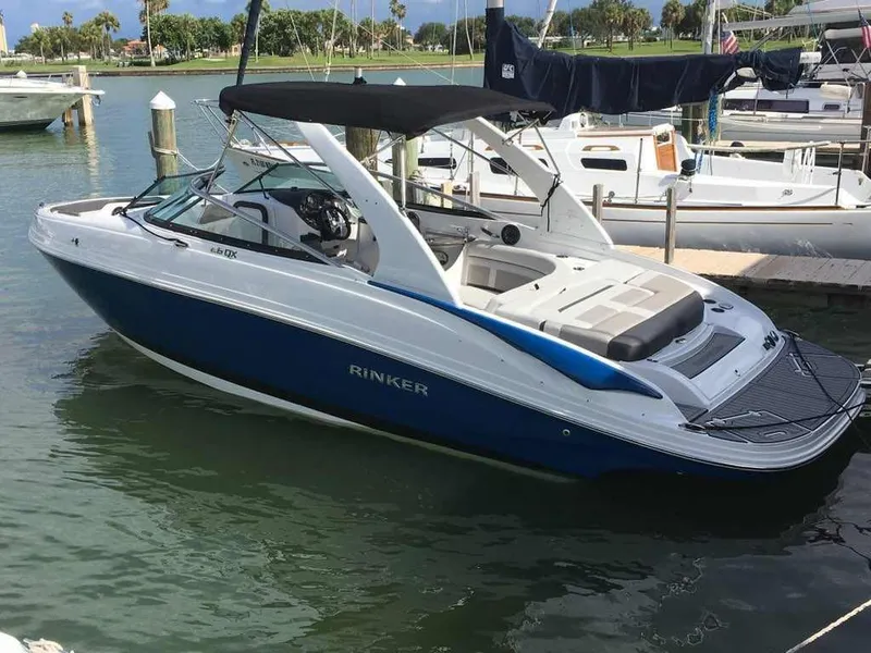 Slide: The Image of 2018 Rinker QX 26 boat docked in a marina. - 21