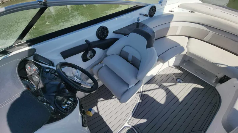 Slide: The Image of 2018 Rinker QX 26 boat interior with steering wheel and seating. - 22
