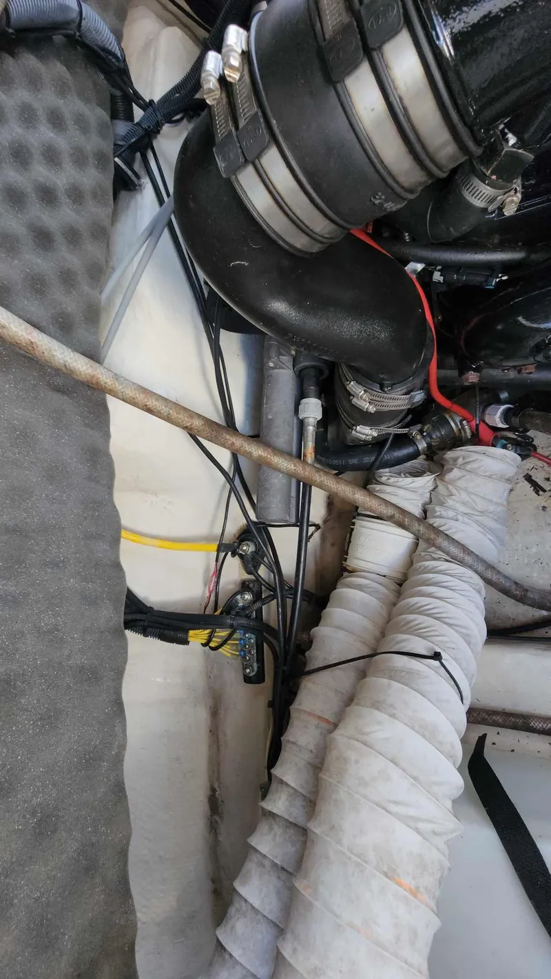 Slide: The Image of Engine compartment of a 2018 Rinker QX 26 boat showing hoses and wiring. - 23