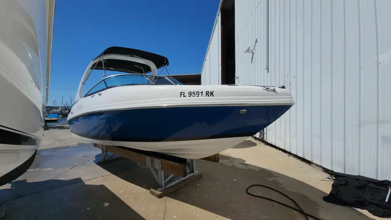 Slide: The Image of 2018 Rinker QX 26 boat in blue and white, docked on a stand. - 29