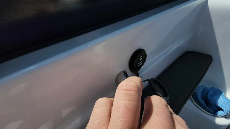 Slide: The Image of Hand plugging in USB cable on 2018 Rinker QX 26 boat. - 30
