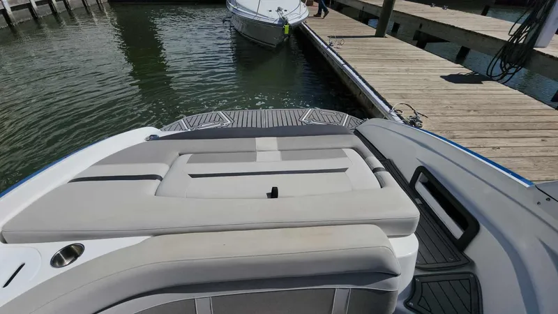 Slide: The Image of 2018 Rinker QX 26 boat docked at a marina, rear seating view. - 32