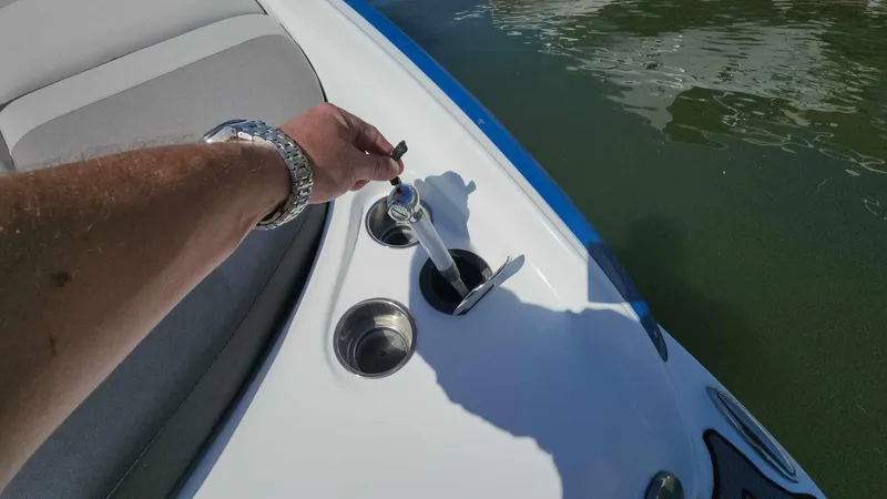 Slide: The Image of 2018 Rinker QX 26 boat with a person using a key near cup holders. - 37