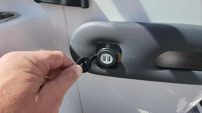 Slide: The Image of Hand plugging USB cable into Rinker QX 26 boat's dual USB port, 2018 model. - 40