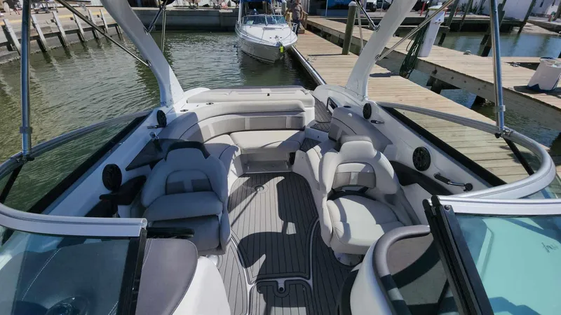 Slide: The Image of 2018 Rinker QX 26 boat interior with spacious seating at a marina. - 42