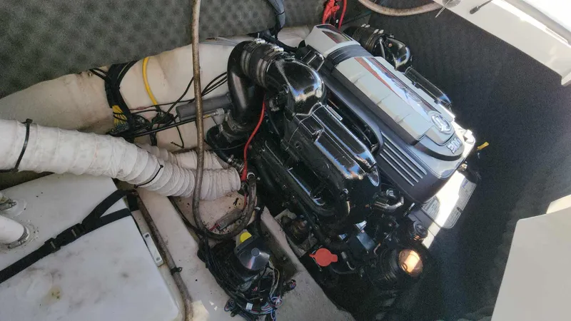 Slide: The Image of 2018 Rinker QX 26 boat engine compartment with visible engine components. - 44
