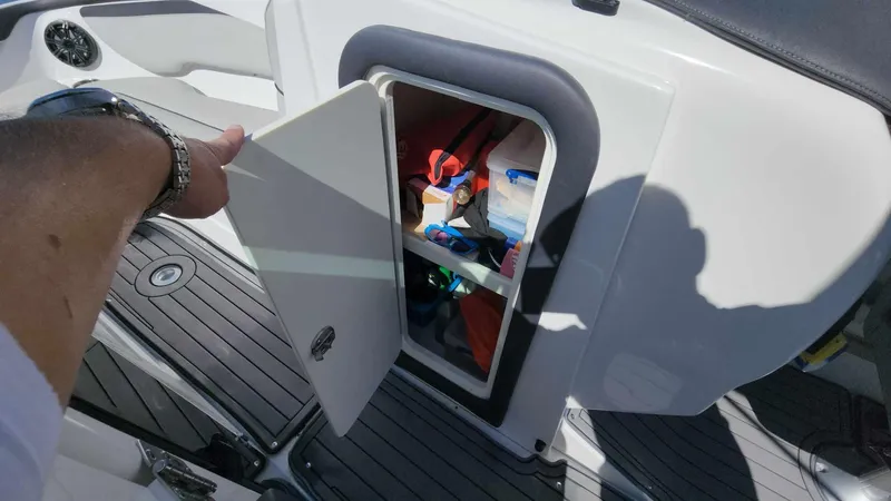 Slide: The Image of 2018 Rinker QX 26 boat storage compartment with open door. - 45