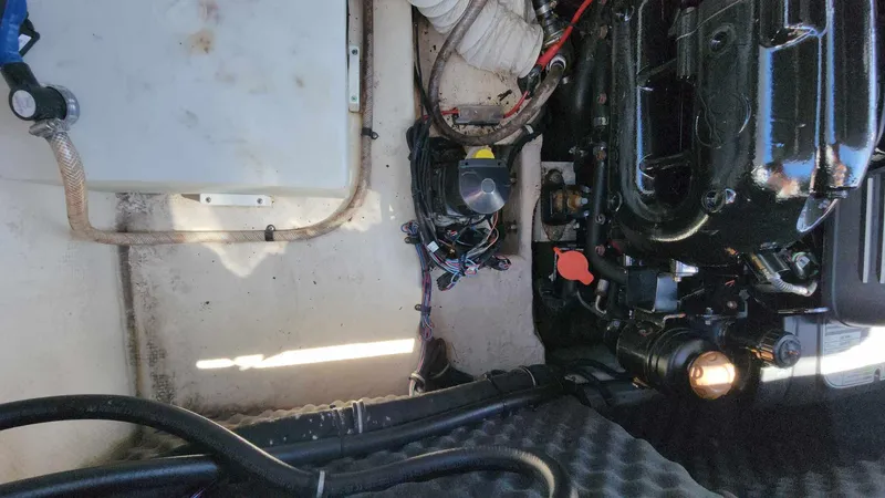 Slide: The Image of 2018 Rinker QX 26 engine compartment with visible wiring and components. - 49