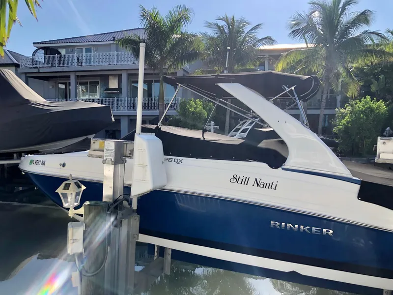 Slide: The Image of 2018 Rinker QX 26 boat docked near waterfront homes. - 8