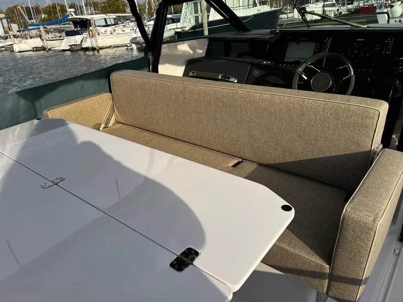 Slide: The Image of 2024 Axopar 37 Sun Top Mediterrana Edition interior with beige seating and white table. - 14