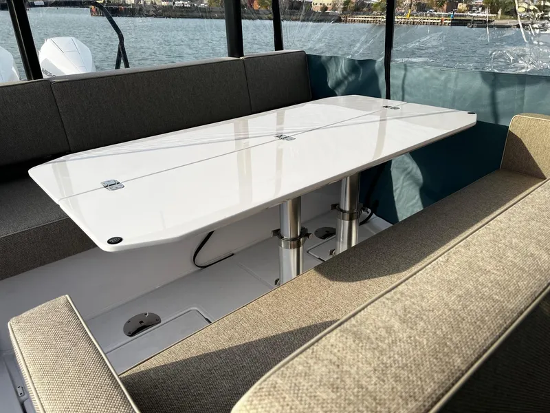 Slide: The Image of 2024 Axopar 37 Sun Top Mediterrana Edition interior with sleek table and cushioned seating. - 15