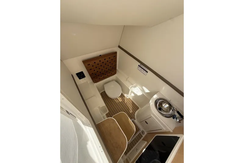 Slide: The Image of 2026 World Cat 325 DC boat interior with toilet, sink, and wooden flooring. - 9