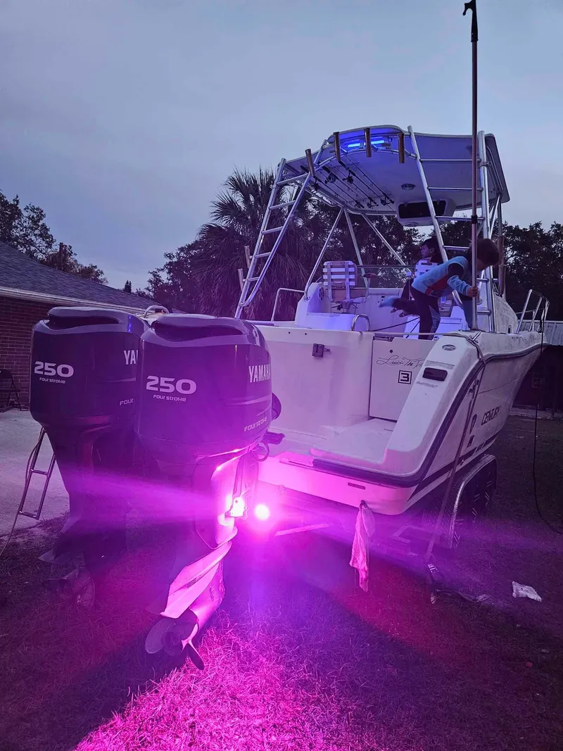 Slide: The Image of 2001 Century 3200 Walk-Around boat with dual Yamaha 250 engines and purple underwater lights. - 10