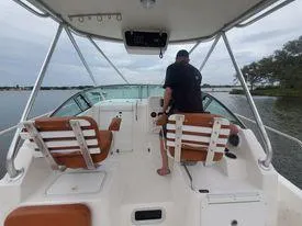 Slide: The Image of 2001 Century 3200 Walk-Around boat interior with person at the helm. - 19