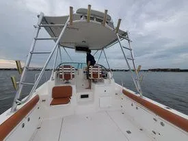 Slide: The Image of 2001 Century 3200 Walk-Around boat on water, spacious deck, fishing rod holders. - 24