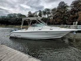 Slide: The Image of 2001 Century 3200 Walk-Around boat docked on a calm river. - 3